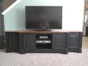 black entertainment console with fluted columns, raised panel doors, concealed hinges and stained oak countertop